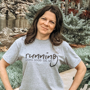 woman wearing running looks good on me performace tee.  Grey with black lettering.